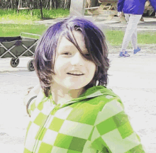 a young boy with purple hair is wearing a green and white plaid shirt