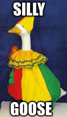 a stuffed goose dressed in a clown costume with the words silly goose above it