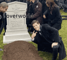 a man kneeling in front of a grave with the word overworld on it