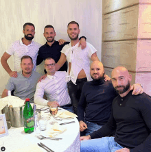 a group of men are posing for a photo with a bottle of perrier water in the foreground