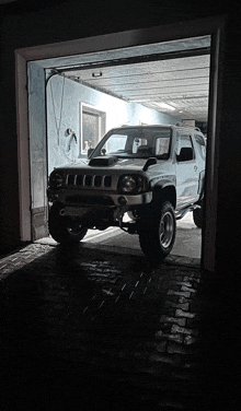 a white jeep is parked in a garage