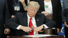 a man in a suit and tie is holding a toy dinosaur in his hands