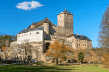 a large castle sits on top of a hill in the middle of a field