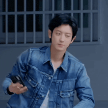 a man wearing a blue denim jacket has a smiley face pinned to his jacket