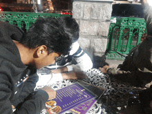 a man in a black sweatshirt looks at a menu for a restaurant