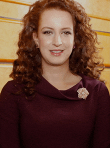 a woman with curly hair wearing a purple dress