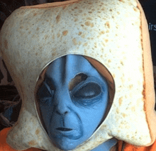 a blue alien is wearing a tortilla hat with a hole in it