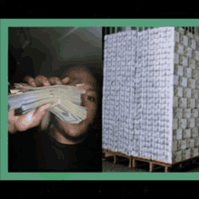 a man is holding a stack of money next to a stack of money