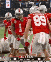 a group of football players are standing on a field and one of them has the number 89 on his jersey