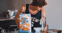 a box of cinnamon toast crunch cereal is on a table next to a man