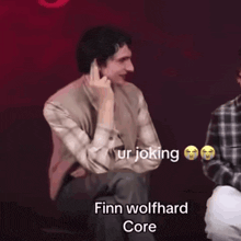 two young men are sitting next to each other with finn wolfhard core written on the bottom