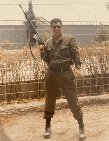 a man in a military uniform is holding a rifle