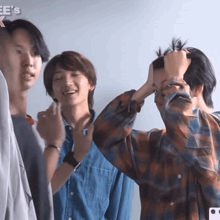 a group of young men are standing in front of a sign that says ' ee 's k '