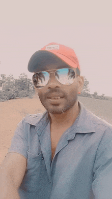 a man wearing sunglasses and a hat that says ' billabong ' on it takes a selfie