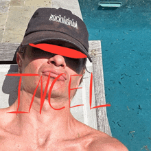 a man wearing a buckingham baseball cap is laying by a pool