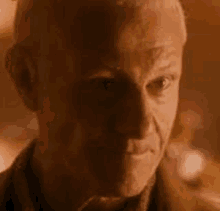 a close up of a man 's face with a serious look on his face in a dark room .