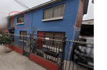 a blue brick building with a red circle around the window