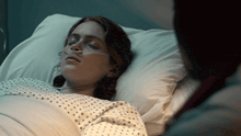 a woman in a hospital bed with an oxygen mask on her nose
