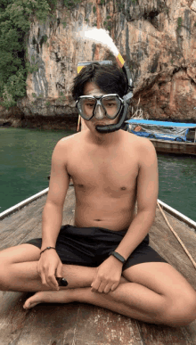 a man without a shirt is sitting on a boat wearing a mask