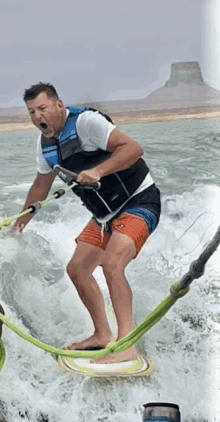 a man wearing a life vest is water skiing in the ocean