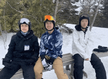 three people are sitting on a bench with one wearing a name tag that says " taylor "