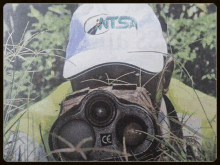 a person wearing a hat that says atsa is standing in the grass