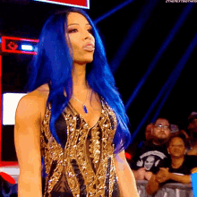 a woman with blue hair is wearing a gold dress and a necklace .