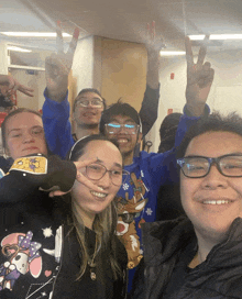 a group of people are posing for a picture with their arms in the air