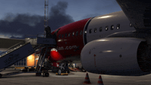 a red and white norwegian.com airplane is parked on the tarmac