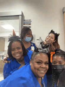 a group of women are posing for a picture with one wearing a halloween costume