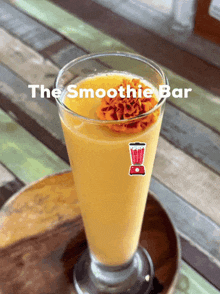 a glass of smoothie with a sticker of a blender and the words the smoothie bar above it