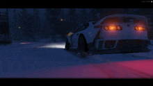 a car is driving down a snowy road at night with the letters m on the side