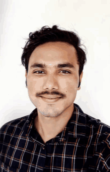 a man with a mustache wearing a plaid shirt