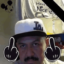 a man with a mustache is wearing a hat and giving a middle finger .