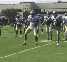 a group of football players are running on a field and one player has the number 31 on his jersey