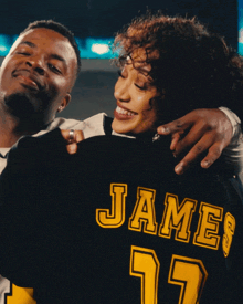 a man and a woman are standing next to each other and the woman is wearing a jersey that says jam