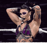 a woman in a purple top has a tattoo on her arm that says ' roman numerals '
