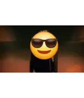 a yellow smiley face wearing sunglasses is standing in the dark