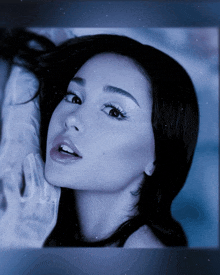 a close up of a woman 's face with a blue sky in the background