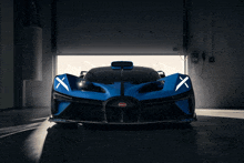 a blue bugatti sports car is parked in a garage