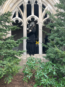 a woman in a black dress is standing in front of a window