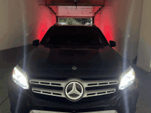 a mercedes is parked in a garage with red lights