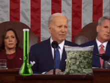 a man in a suit is giving a speech in front of a bag of marijuana