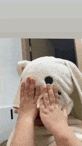 a child is covering their face with a bunny shaped blanket