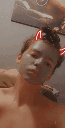 a shirtless boy with a mask on his face has a devil horn on his head