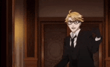 a man in a suit and tie is standing in front of a door and waving .
