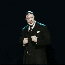 a man in a suit and tie with a red face painted on his face