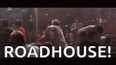 a group of people are dancing in a dark room with the words `` roadhouse '' written in white letters .