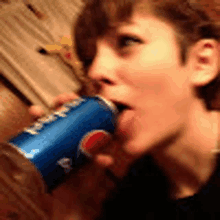 a woman is drinking a can of pepsi .