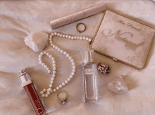 a bottle of miss dior perfume sits next to a necklace